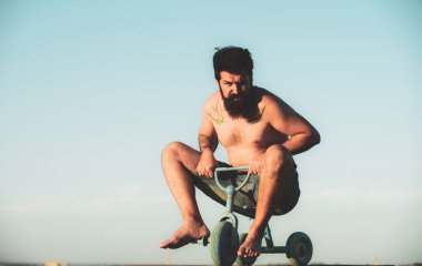 Küçük bir bisiklet süren çılgın bir adam. Komik bisikletçi. Komik adam bisikleti sürüyor..