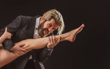 Kadın bacaklı, takım elbiseli yakışıklı bir adam. Ayak fetişisti. Lüks ve ataerkil düzen. Bacağını yala..