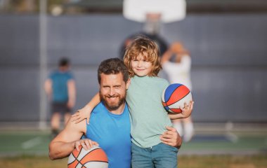 Baba ve oğlu basketbol oynuyor. Baba ve oğlu dışarıda basketbol oynuyorlar. Çocukluk ve ebeveynlik kavramı.
