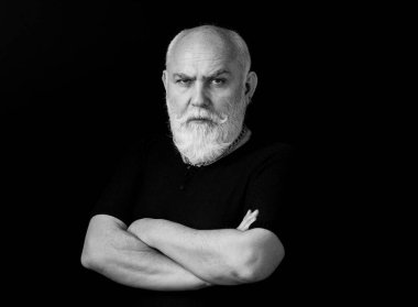 Ciddi bir kıdemli. Siyah arka planda olgun bir adamın portresi.