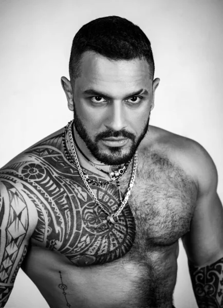 Seksi dövmeli adam. Erkek modası. Atletik vücudu olan kaslı maço bir adam. Kendine güven karizması. Spor sağlık sigortası. Vahşi sporcu gövdesi. Steroitler. Spor başarısı. Sağlıklı yaşam tarzında başarı