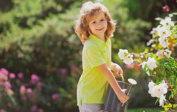 Милий маленький хлопчик дитина поливає квіти з балончиком. Дитячий садівництво . — стокове фото