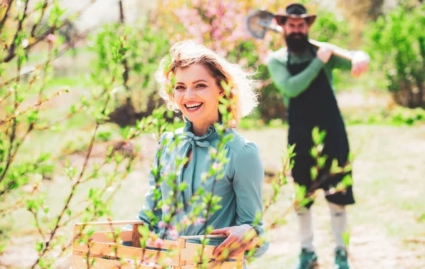 Bella donna che lavora e gioca in un bellissimo giardino. Bella donna sullo sfondo con fiori in un giorno di primavera. Donna piantare fiori . — Foto Stock
