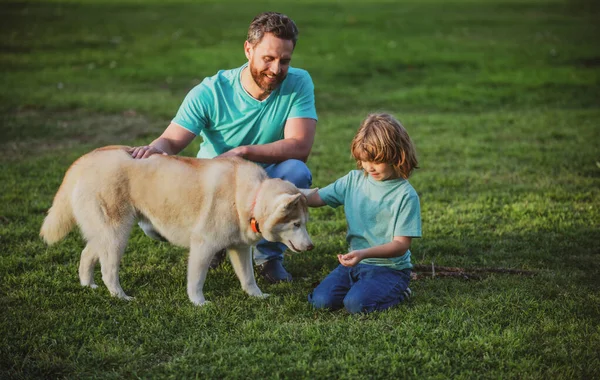 Padre e hijo con perro mascota pasar tiempo al aire libre juntos. —  Fotos de Stock