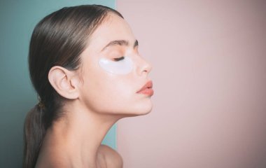 Derisinin icabına bakıyorum. Kadın göz yamaları kullanarak evde zaman geçiriyor. Günlük şımartıcı rutin. Makyaj yapmak yerine ilk bakım. Modern kozmetik. Göz yamaları kavramı. Nemlendirme göz yamaları