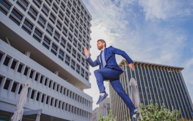 Şehir arka planında hızlı koşan bir iş adamı.