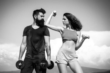 Sportif iki gökyüzü arka plan üzerinde dumbbells ile çalışma dışarı. Sağlıklı yaşam konsepti. Güzel çekici fitness arkadaşlar. ABS fitness kadın vücut. Açık havada egzersiz spor giyim kadın modeli.