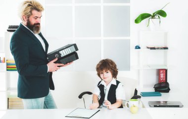 Şirin bir çocuk ofis koltuğunda kendinden emin oturuyor. Büyük patron, komik iş adamı patronluk taslayan çocuklar, yönetmen ve güçlü lider kavramı gibi. İş adamlarının toplantısı var..