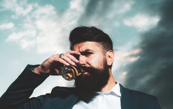 Närbild av en stilig snygg skäggig man njuter av konjak eller whisky. — Stockfoto