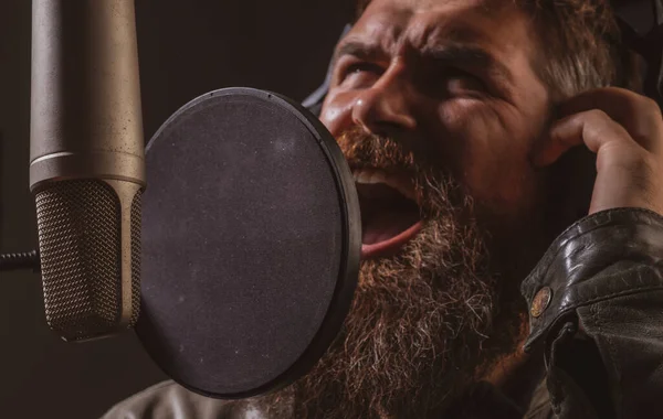Vyjadřující tvář zblízka. Zpěvák zpívající rock. Zvuková producentka nahrává písničku v hudebním studiu. Vzrušené karaoke. — Stock fotografie