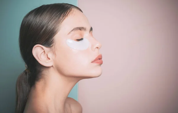 Cuidando su piel. Mujer que usa parches para los ojos y pasa tiempo en casa. Rutina diaria de mimos. Primero cuidado que maquillarse. Cosmética moderna. Concepto de parches oculares. Parches hidratantes para los ojos —  Fotos de Stock