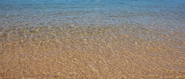 海の背景は、太陽の光と熱帯夏のビーチの性質。砂のビーチ、コピースペース付きの海の水、夏休みのコンセプト. — ストック写真