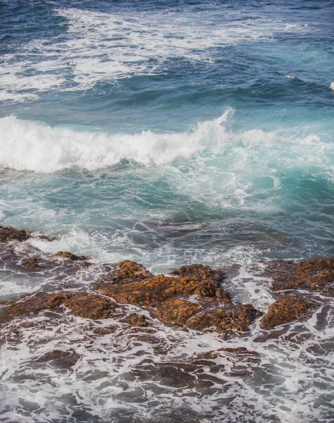 Spetterende golven op de rots in de zee. Wave raakte de steen in de oceaan met een waterbuis achtergrond. — Stockfoto