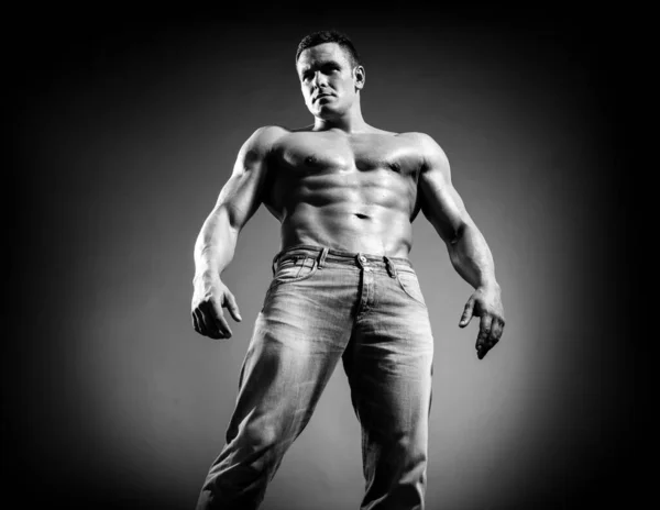 Sexy muscle fort visage guy en jeans sur fond gris isolé. — Photo