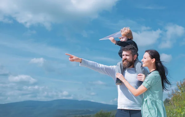 Gelukkige familie - moeder, vader en zoon op hemelse achtergrond in de zomer. Droom van vliegen. Gelukkig gezin vader en kind op weide met een vlieger in de zomer op de natuur. — Stockfoto