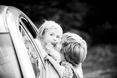 Araba yolculuğundan önce küçük komik bir çift hoşça kal diyor. Elveda çocuk konsepti. Küçük oğlan tatlı kız için öpücük verir. Araba yolculuğundan önce hoşça kalın..