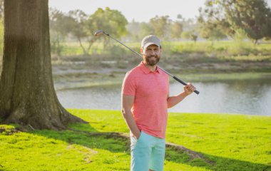 Golfçü golf sahasında golf sopası kullanıyor..