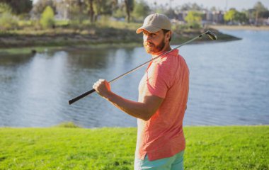 Golfçü akşam golf sahasında golf oynuyor. Güneşin altında golf oynayan bir adam..