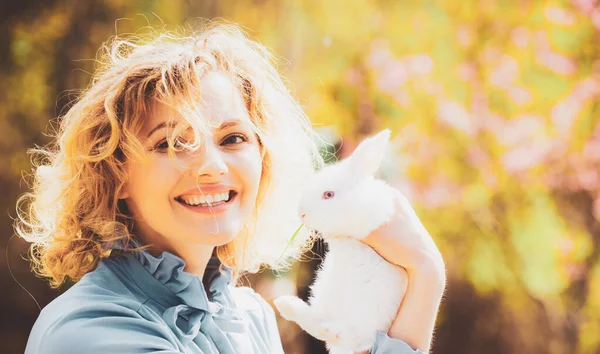 Funny Easter rabbit. Beautiful young woman with bunny rabbit on farm. Portrait of young woman posing with rabbit. — Stock Photo, Image