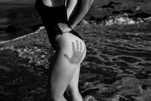Closeup sexy butt with hand prints of woman in swimsuit at the barbados or virginia, beach. Women sensual body. Tanned booties of young model in bikini. — Stock Photo, Image