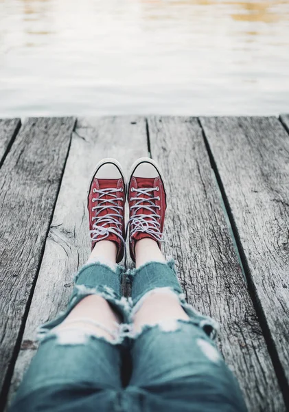 Yalnız emo kırmızı spor ayakkabı içinde oturuyor. Ergenlik sorunları. Rüya ve yalnızlık zaman.