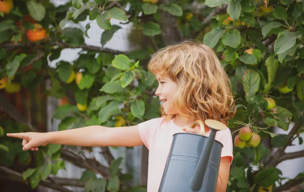 Çocuk bahçede çalışıyor, çiçekleri suluyor..