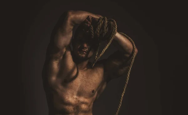 Мускулистые плечи. Мужественность, сила и сила. Здоровый мускулистый молодой человек с веревкой. — стоковое фото