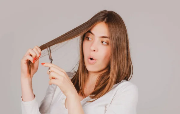 Funny woman with scissors having hair cut. Beautiful girl with straight hair with professional scissor. Haircare concept. — Stock Photo, Image
