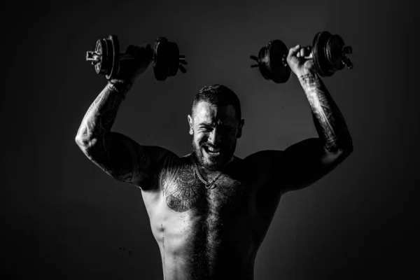brutal sportsman with barbell. steroids. confidence charisma. sexy abs of tattoo man. male fashion. muscular macho man with athletic body. sport and fitness. dumbell lifting. training with coach