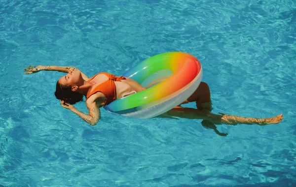 Yaz tatili. Güneşlenmenin tadını çıkarıyorum. Yüzme havuzunda şişme dairede mayo giymiş bir kadın.. — Stok fotoğraf
