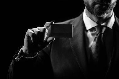 Kredi kartı sahibi bir iş adamı. Elinde boş bir kredi kartı modeli var. Kredi kartı el ele tutuşmanın şablonunu oluşturur. Banka kartı. Ticari marka.