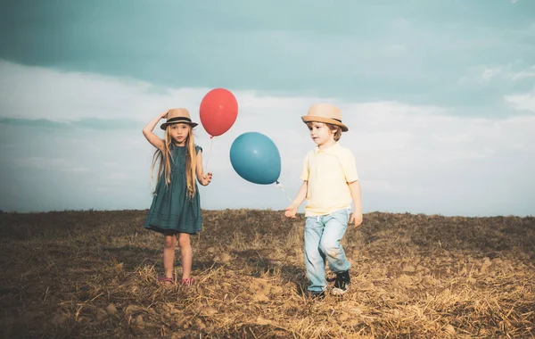 Balonlu şirin bir çift. Sevimli çocuklar eğleniyor. Dışarıda eğlenirken. Yüzünde duygular var. Yakın arkadaşlar. Çocuk bakımı.