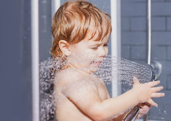 Hij heeft plezier in bad. Grappige vrolijke baby baadt in bad met water en schuim. Kinderhygiëne. — Stockfoto