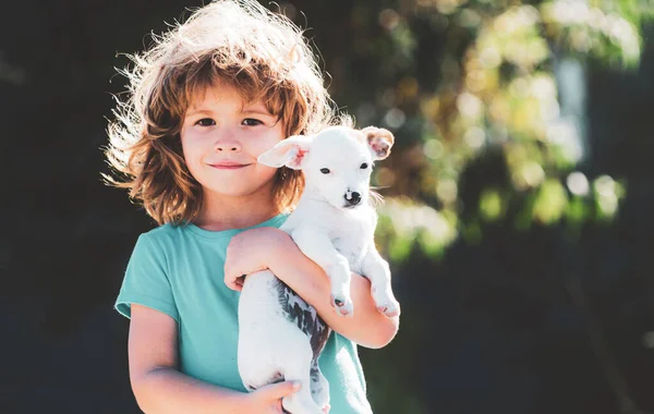 Cute kid hugging dog. Child and puppy playing outside. — Stock Photo, Image