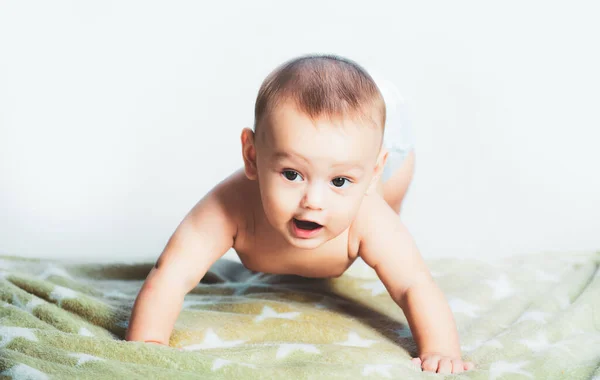 Little baby crawling on the bed. Happy kid playing. Cute little baby in diaper. Beautiful smiling cute child. Portrait of a crawling baby on the bed in room. — ストック写真