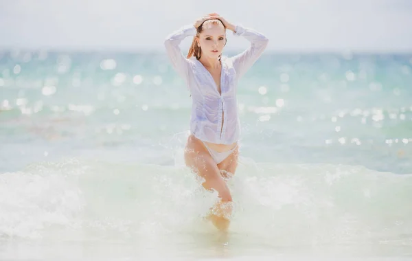 Sinnliches Mädchen in weißem Hemd und Bikini im Urlaub am tropischen Strand. Sexy Frau auf See. Nasses sexy Kleid. — Stockfoto