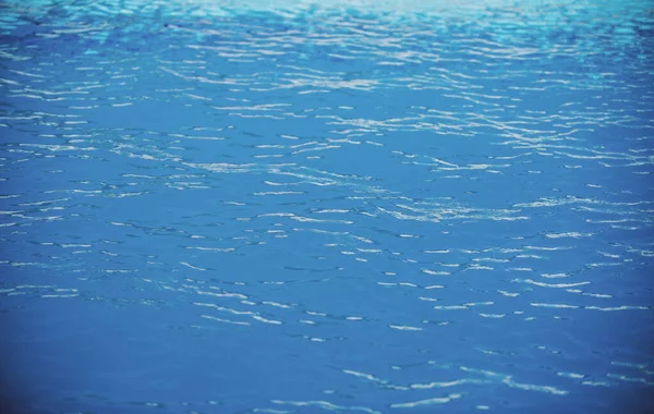Ripple Water in het zwembad met zon reflectie. Golvende waterachtergrond. — Stockfoto