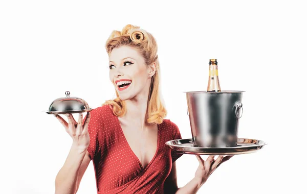 Vacker blond kvinna i röd klänning med retro frisyr. Glad tjej med champagneflaska och bricka. Sätt upp stilen. Glad upphetsad kvinna i retro klänning med vacker frisyr. — Stockfoto