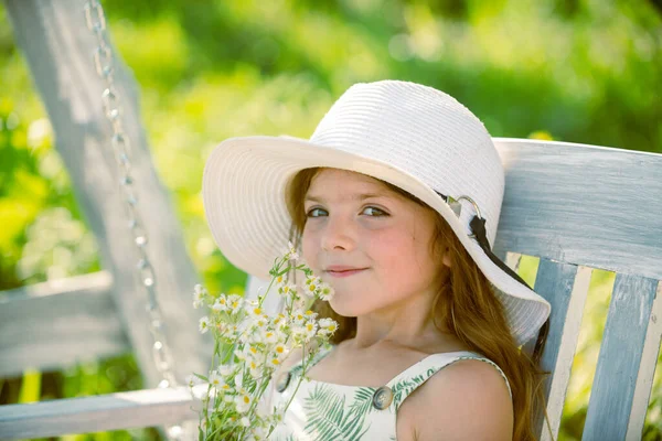Çiçek açan yaz bahçesinde çiçek toplayan sevimli küçük kız çocuğu. Bahar çocuğu suratı. Yazın çimlerin üzerinde çiçeklerle mutlu küçük bir çocuk. Bahçedeki çayırda küçük şirin bir çocuk.. — Stok fotoğraf