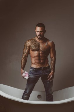 Çıplak vücutlu, küvette yıkanan seksi adam. Erkek model banyoda baştan çıkarıcı, vahşi banyo, çıplak gövde..