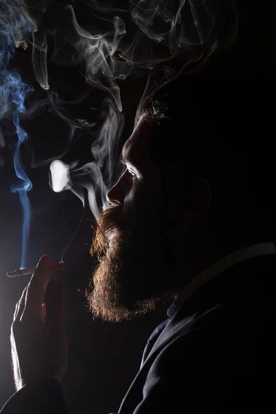 Close up portrait of man bearded man smoking cigarette. Cigarette smoke on black background. — Fotografia de Stock