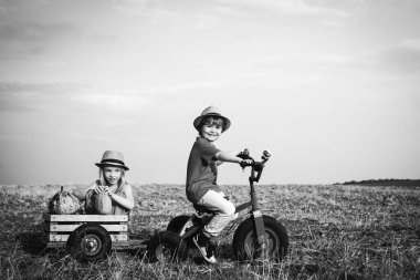 Bisikletli iki genç çiftçi. Köy hayatı. Mutlu bir çocukluk. Çiftlikte iki küçük çocuk..