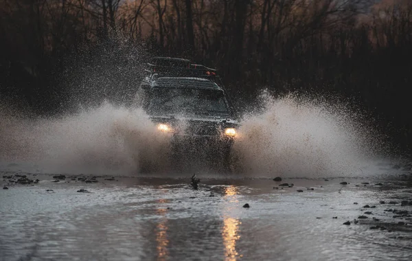 4x4 yolculuk gezisi. Bir su birikintisine çarptım ve toprak püskürttüm. Açık hava maceraları. Güzel doğa. En iyi off road araçları. Ralli yarışı. Safari SUv. Off-road. Dağda off-road yolculuğu