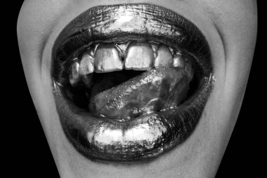 Dudaklarında altın boya var. Altın dudaklar, şehvetli kadın ağzı. Metalik yaratıcı sanat yakın plan. Altın kavram. Seksi dilli. Şehvetli yalama.