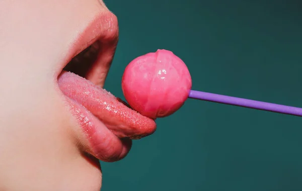 Nyalogatom a nyelvem. Ajkak cukorkával, szexi édes álmok. Női száj nyalogatja chupa chups, szopás nyalóka. — Stock Fotó