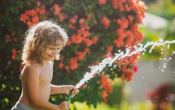 Kid have fun. Funny boy happy smiling on natural landscape. Little child have fun on fresh air. Being funny is one of my greatest strengths. Watering plants in the garden at home on summer sunny day.