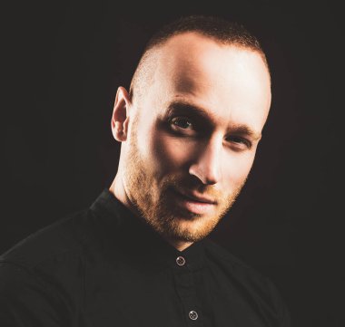 30 yaşındaki çekici bir adamın moda portresi. Yakışıklı bir gencin yakın portresi. Siyah arka planda poz veren yakışıklı sakallı adam..