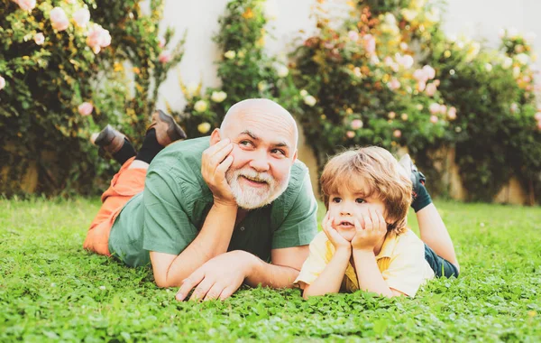 İki farklı nesil: büyükbaba ve torun birlikte. Sevgi dolu bir aile. Mutlu büyükbaba ve çocuk torun güler ve yazın doğada birlikte eğlenirler..
