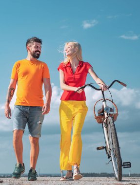 Güzel kız arkadaşıyla aşk yolunda oynaşan genç bir adam. Mavi gökyüzü arka planında retro motorlu yaz kadını. Trend. Güneşli bir günde bisiklet süren çekici bir çift..