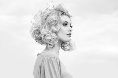 Güzel mavi gözlü seksi, beyaz bir kadının yakın plan portresi. Gökyüzü arka planında.